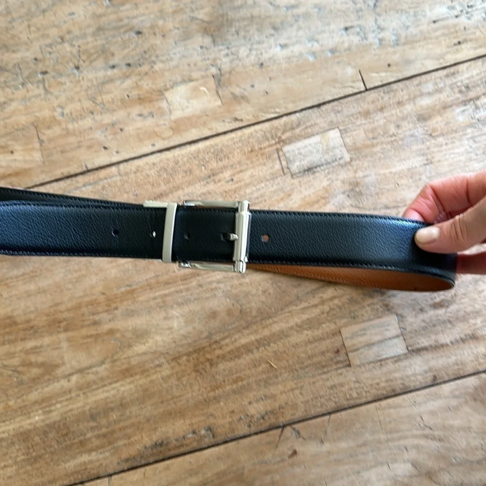 Reversible black and tan belt with silver buckle. Size 32.